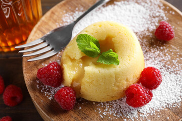 Tasty vanilla fondant with white chocolate and raspberries on table, closeup