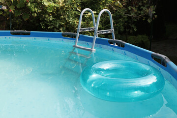 Fototapeta na wymiar Inflatable ring floating on water in above ground swimming pool outdoors
