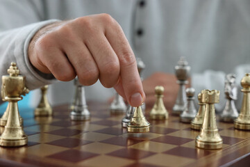 Man moving chess piece at checkerboard, closeup