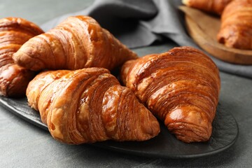 Delicious fresh croissants on grey table, closeup