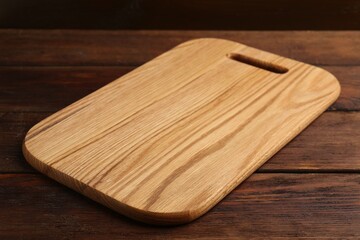 One new cutting board on wooden table, closeup