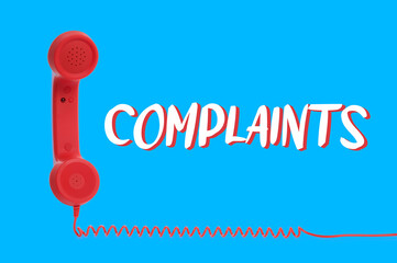 Corded telephone handset and word complaints on light blue background