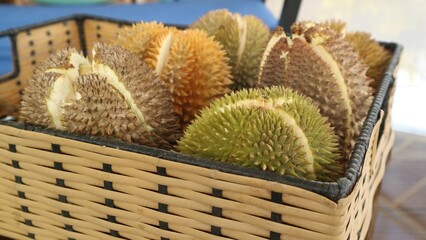Close up view of a batch of durians in a wooden basket ready for sale