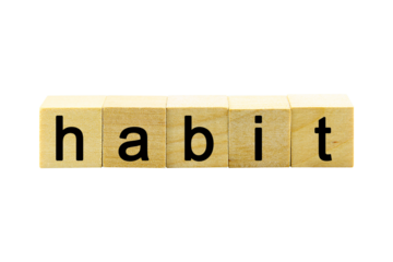 "habit" text or message short word english letter on a small wooden cubes block with white background.