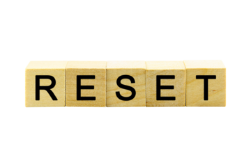 "RESET" text or message short word english letter on a small wooden cubes block with white background.