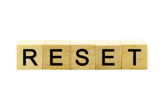 "RESET" text or message short word english letter on a small wooden cubes block with white background.
