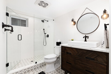 A cozy bathroom with a dark wood cabinet and vessel sink, an mosaic pattern tile flooring, and...