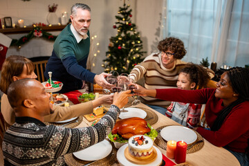 Multi-ethnic big family celebrating Christmas party together in house. 