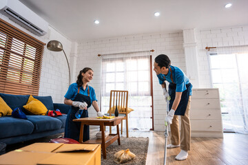 Asian young man and woman cleaning service worker work in living room. - obrazy, fototapety, plakaty