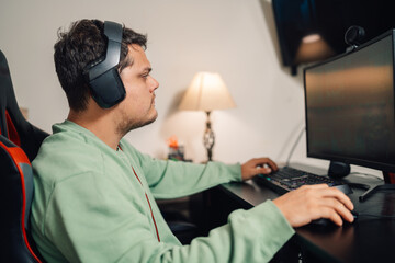 Gamer using headphones to play with the computer