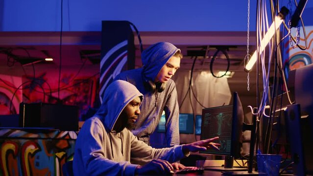 Hackers brainstorming ways of using network vulnerabilities to exploit servers, trying to break computer systems at night. Rogue developers work together on breaching networks