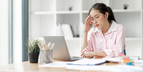 Obraz na płótnie Canvas Young busy stressed upset Asian businesswoman feeling tired frustrated, sitting at office desk,