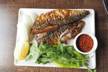 fried fish served with lettuce , lemon on a plate 