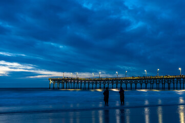 Fototapeta na wymiar Ocean Pier with Stormy Cloud Background before Sunrise
