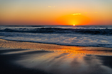 Fototapeta na wymiar Beach Sunrise (sun on right) with reflecting wet sand