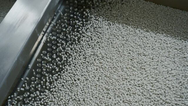 Cleaning of polymer granules. Creative. Mesh for cleaning white polymer granules from debris and foreign particles. Chemical workshop for plastic processing and cleaning