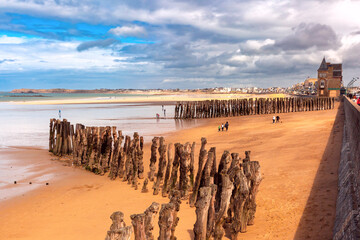 Wooden breakwater and beach at low tide, in walled port city of Saint-Malo, Brittany, France