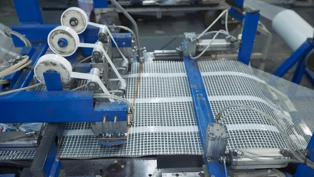 Automated Polymer Mesh Machine. Creative. Machines laying heating wires on polymer grid. Industrial production of modules for floor heating