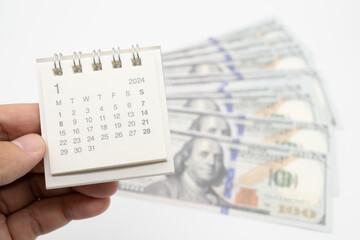 Obraz premium 2024 Jan Calendar and US dollars. Pension Concept. Bonus Money. isolated on white background.