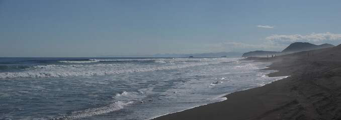 Khalaktyrsky Black sand beach scenic panorama with distant mountains on sunny day, Kamchatka famous...