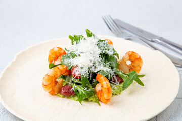 beautifully served shrimp with arugula and grated cheese, side view