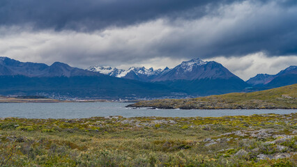 Picturesque snow-capped Andes mountains against a cloudy sky. In the foreground is the Beagle...