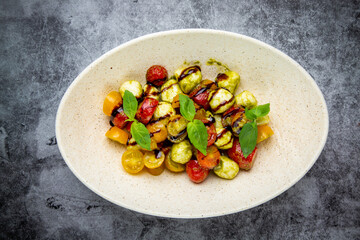  salad of yellow and red cherry tomatoes of different varieties with herbs side view