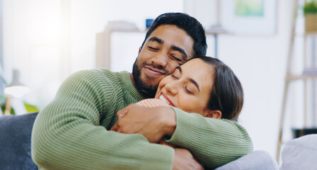 Obraz premium Happy, hug and couple on a sofa with love, relax and security at home bonding, hanging out or chilling. Smile, support and people in living room with trust, commitment and gratitude, care or romance