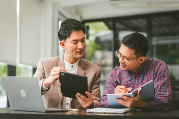 Two professionals in meeting, one presenting 