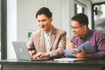 Two professionals in meeting, one presenting "Business, Plan, Success" on whiteboard, another observing and holding a clipboard. Asian businessman, Colleagues, Middle-age