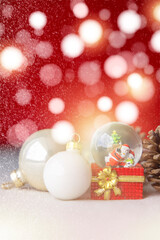 Fototapeta na wymiar Christmas balls, Santa Claus in a Snow globe, and Pine cones on a Cream-Colored Cloth, set Against a Red Background and exquisite bokeh. New Year Celebration Atmosphere, about of Important day.