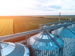 Modern metal silos on agro-processing and manufacturing plant. Aerial view of Granary elevator...