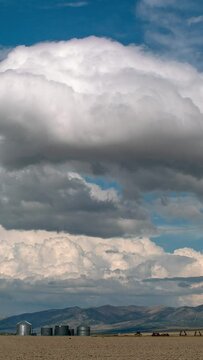 Vertical Clouds rolling over farm landscape in northern Utah viewing silos and grain bins.