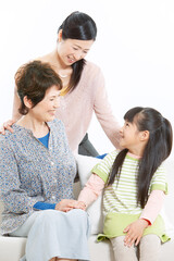 ソファーに座る三世代家族