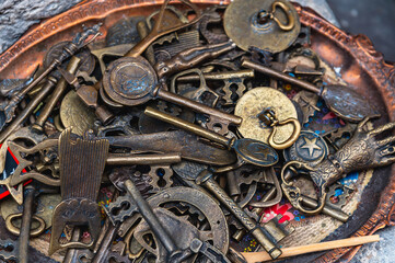 Metal tray with antique keys and decorative objects.