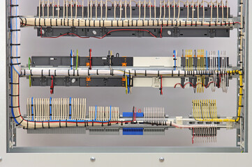 Stranded mounting wires assembled into a bundle with plastic ties. View from the back of the electrical switchboard.