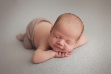 Sleeping newborn baby boy in suit posing on blue fabric 