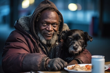 Portrait of old African American homeless man sitting on street and eating with his hungry dog....