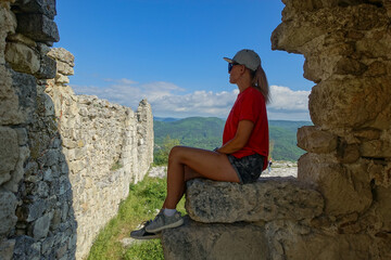 Fototapeta premium Mangup-Kale cave city, sunny day. A girl on the background of a mountain view from the ancient cave city of Mangup-Kale in the Republic of Crimea, Russia. Bakhchisarai.
