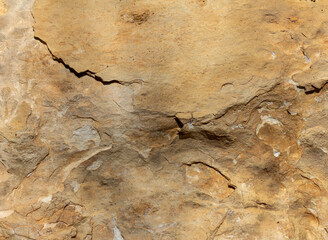 Natural stone walls are the entrance to a cave on a steep cliff of a mountain canyon