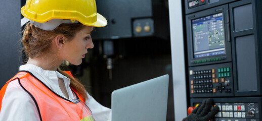 Female engineer worker using computer laptop connecting to controlling machine at the manufacturing factory. Technician checking or maintenance system of the industrial