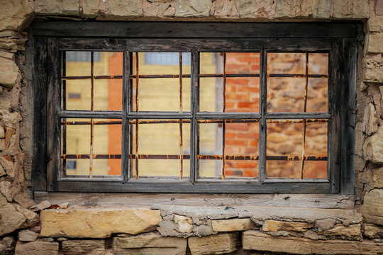Weathered Abandoned Building Exterior with Damaged Walls and Old Windows. Place of imprisonment, Prison with the old window