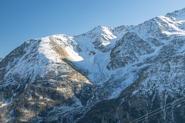 Panoramic view of snow-capped mountain peaks in clear sunny weather. Vacation at a ski resort high...