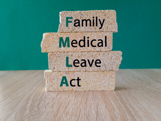 FMLA family medical leave act symbol. Concept words FMLA family medical leave act on brick blocks....