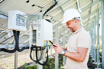 Enthusiastic man happy about launching solar panel. Smiling worker reporting on well done job. Man...