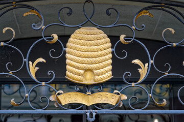 Close-up of golden bee hive and wrought iron at the old town of Swiss City of Bern on a cloudy...