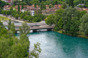 Fototapeta na wymiar Scenic aerial view of Aare River with trees alongside urban road at Swiss City of Bern a cloudy summer day. Photo taken July 1st, 2023, Bern, Switzerland.