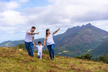 Parents showing landscape to a little boy in the mountain
