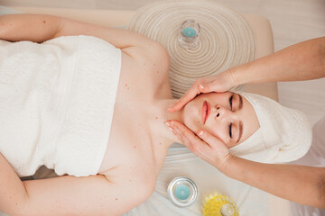 Obraz na płótnie Canvas Female masseur doing therapeutic facial massage in spa