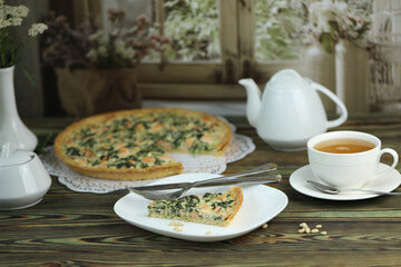 Delicious Quiche pie with salmon fish and pine nuts filling. Breakfast with quiche and cup of tea